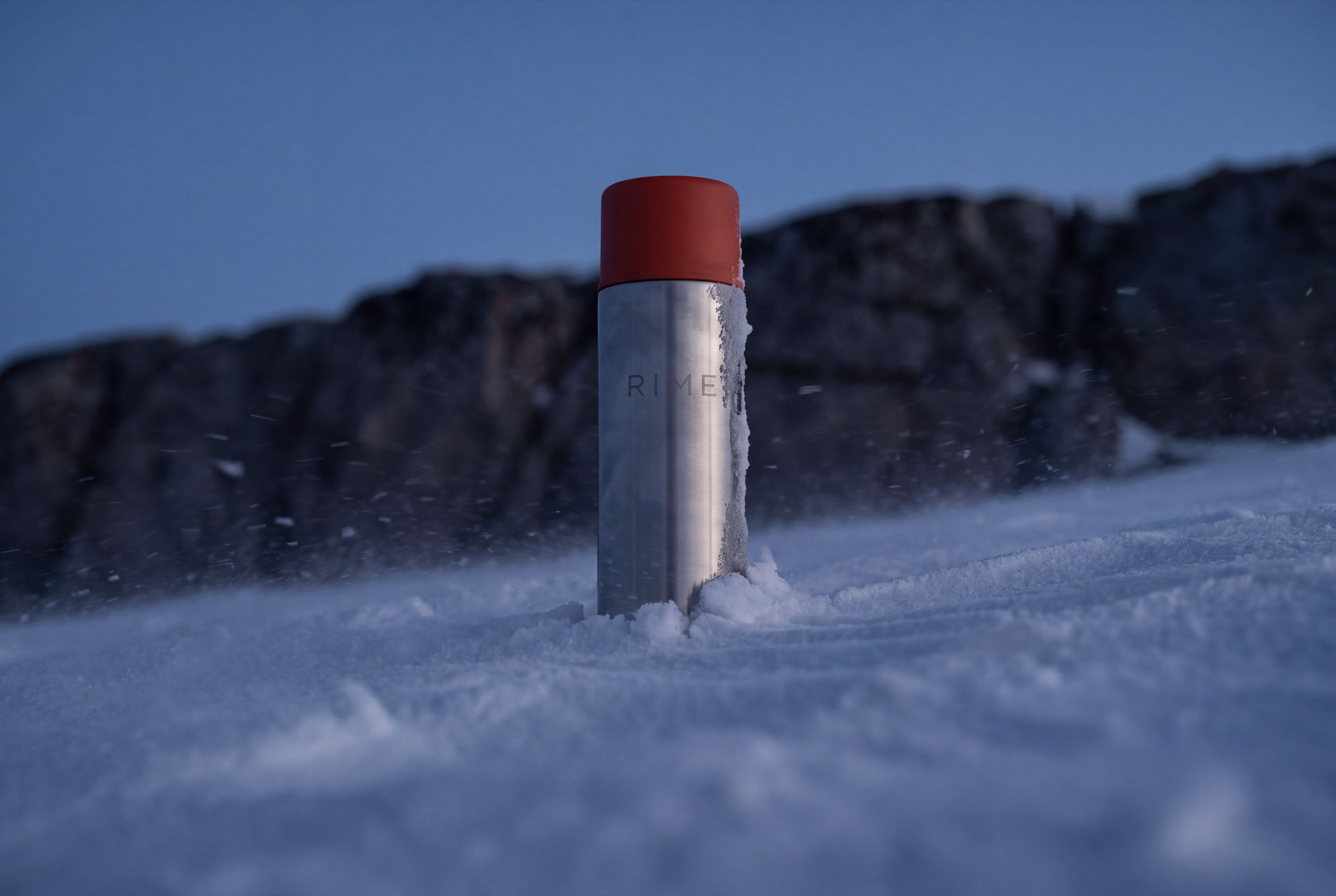 The flask half-buried in wind-scoured snow
