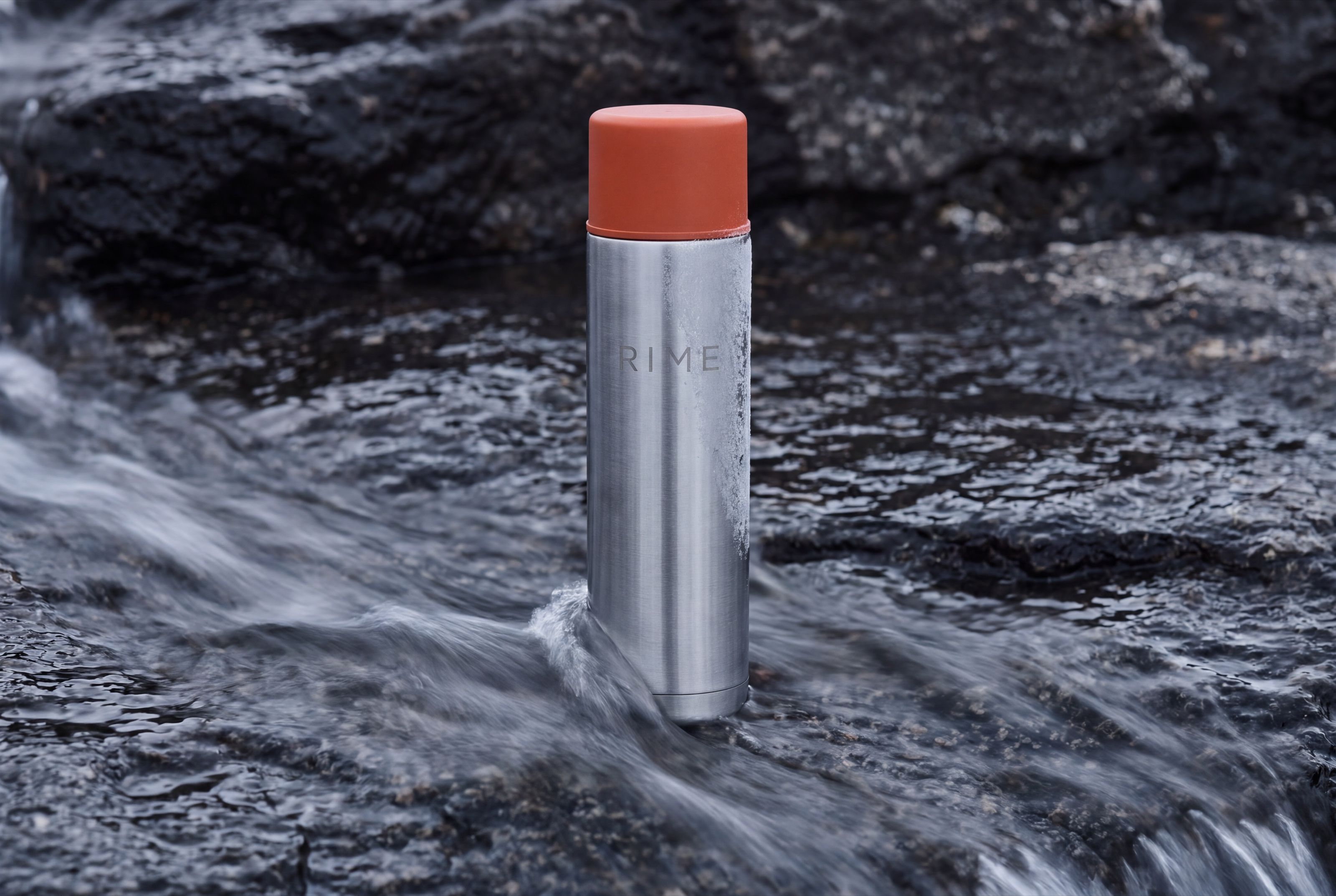 The flask on wet granite with meltwater running past its base