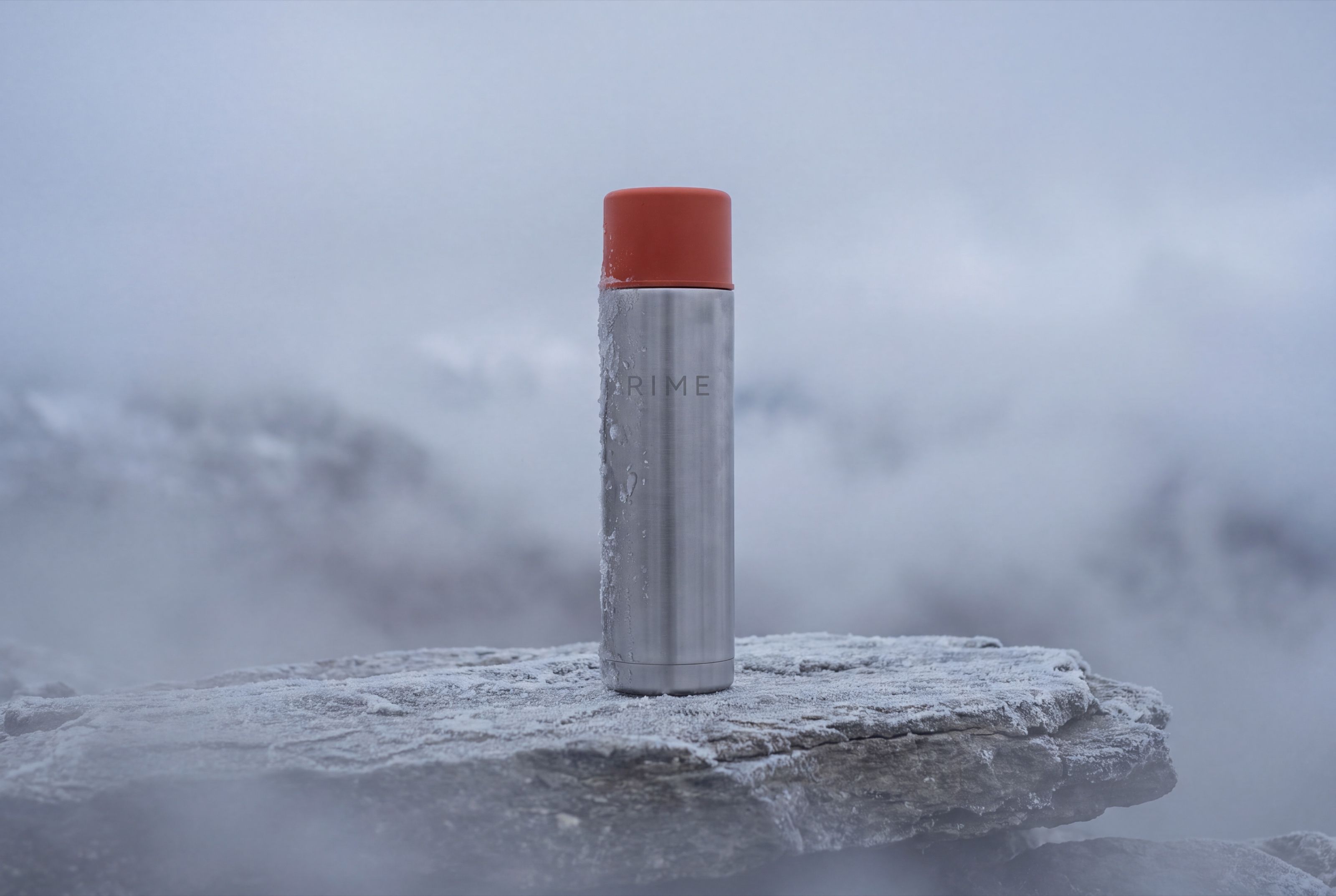 The flask on a ledge in drifting fog above a sea of cloud