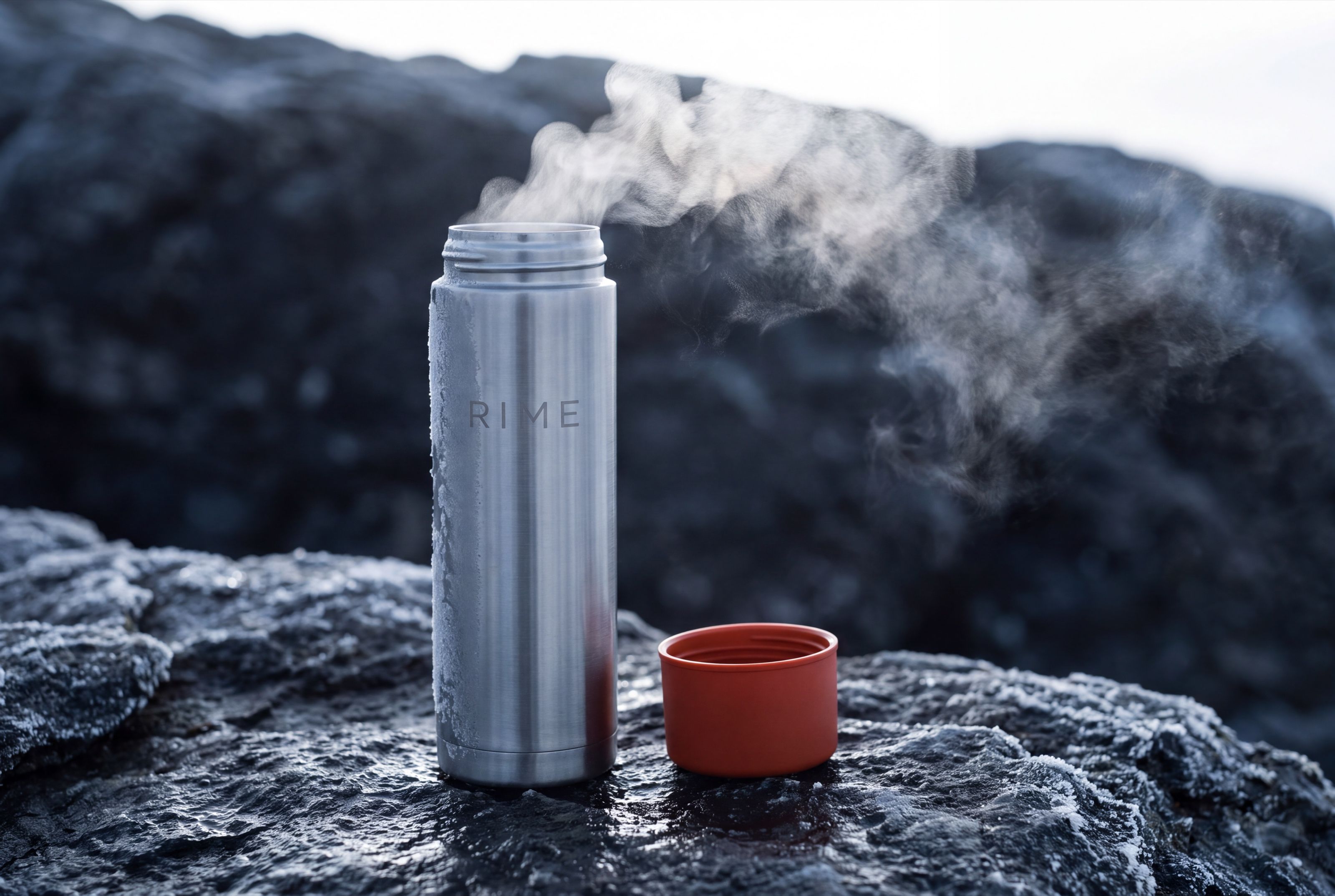 Steam rising from the open flask cup, backlit against cold air